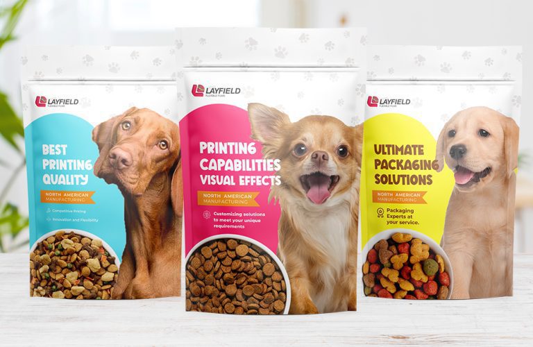 Three stand-up pouches for dog treats featuring custom printing designs and Layfield branding.