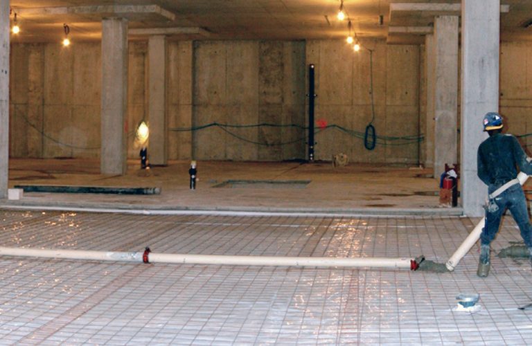 Vapor barrier installed beneath rebar grid in a commercial construction site for moisture control and slab protection.
