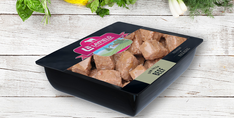 Black tray of raw beef pet food sealed with clear lidding film and Layfield branding.