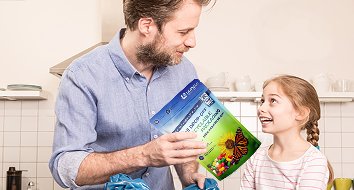 Man and young girl in kitchen holding Layfield flexible pouch featuring Store Drop-Off recyclable packaging labeling.