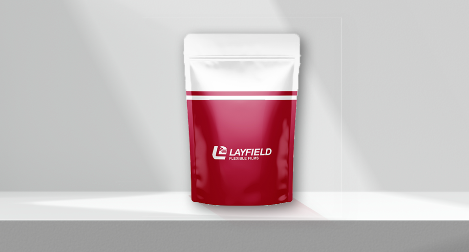 Red and white stand-up pouch with zipper closure featuring the Layfield Flexible Films logo, displayed on a minimal white background.