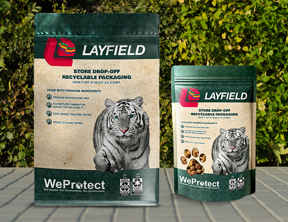 Two Layfield flexible pouches featuring Store Drop-Off recyclable packaging labels, displayed outdoors.