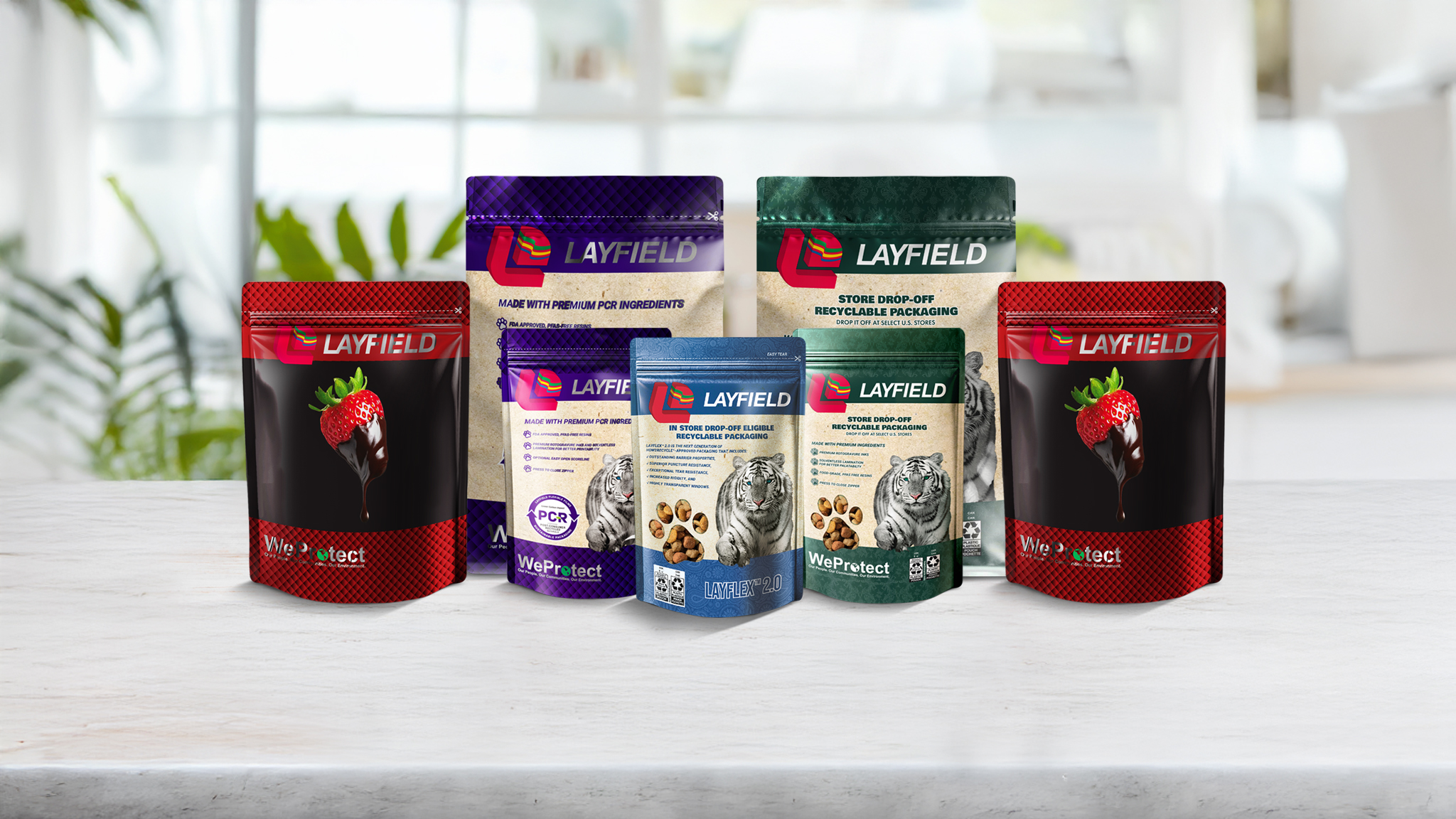 A selection of Layfield's food packaging solutions in various sizes and designs, displayed on a white surface with a blurred kitchen background.